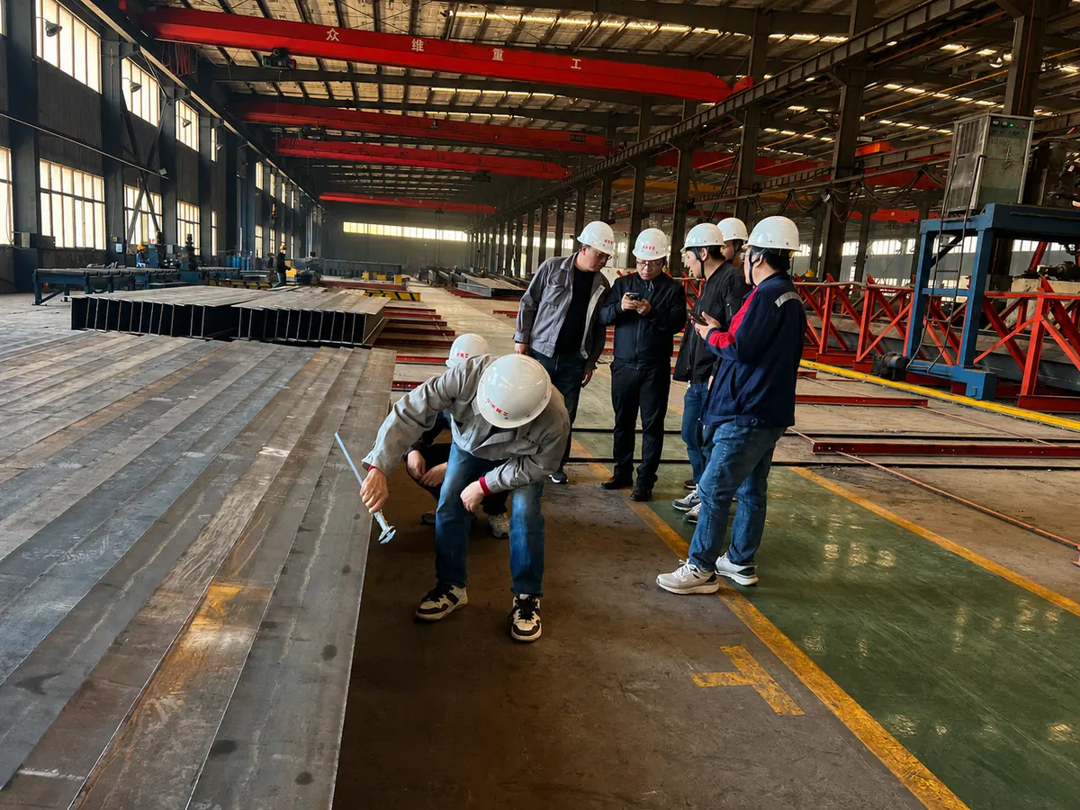 Main contractor inspection team measuring fabricated H-section members in the Zhongwei workshop